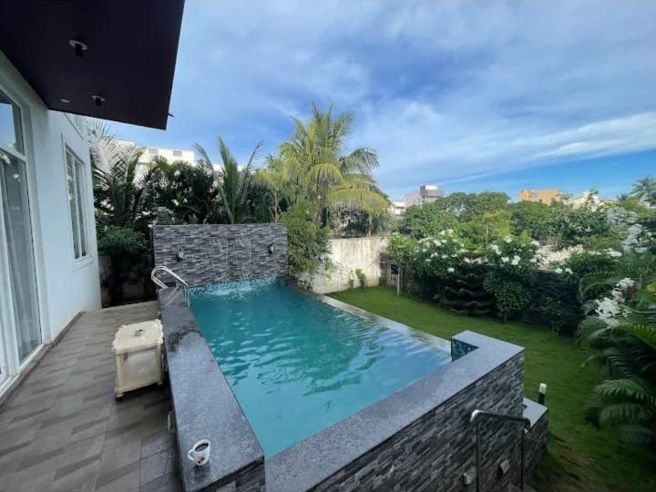 Private pool with waterfall wall and palm trees